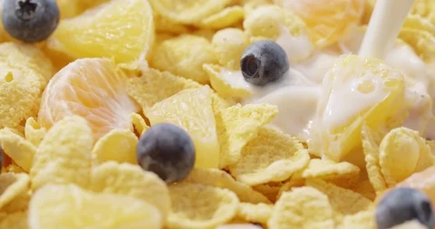 Corn Flakes with blueberry and mandarin pouring with Yogurt Stock Footage 124740242