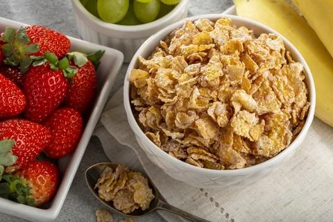 Corn flakes in the bowl with berries on the table. Stock Photos