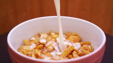 Corn flakes in a bowl pour with milk Video stock 80486797