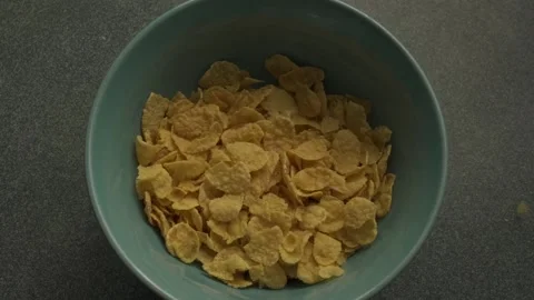 Corn flakes for breakfast poured into bowl slow motion, close-up cook breakfast Stock Footage 233112357