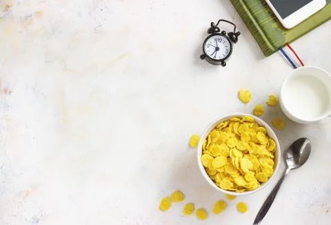 Corn flakes, coffee, alarm clock on a light background, breakfast Stock Photos