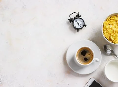 Corn flakes, coffee, alarm clock on a light background, breakfast Stock Photos