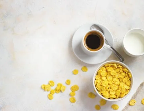 Corn flakes, coffee, alarm clock on a light background, breakfast Stock Photos