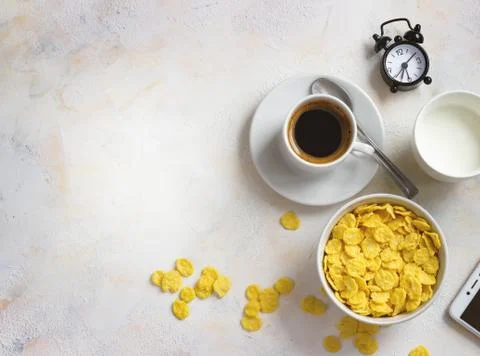 Corn flakes, coffee, alarm clock on a light background, breakfast Stock Photos