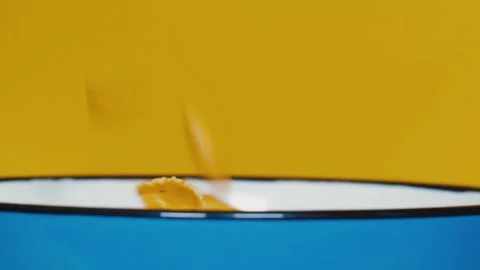 Corn flakes falling into blue bowl Stock Footage 142436571