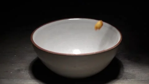 Corn flakes falling into Bowl. Milk pouring into cereal bowl in slow motion.  Stock Footage 130376508