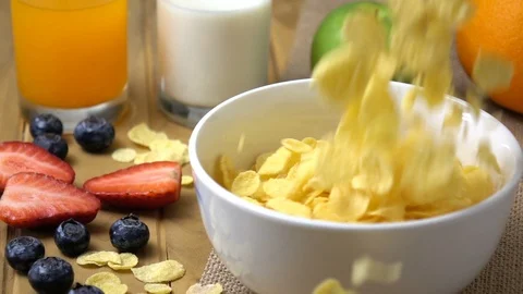 Corn flakes falling in to a bowl in slow motion. Stock Footage 94086695