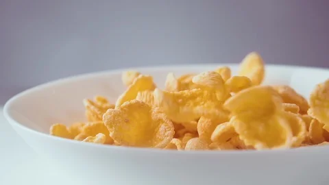 Corn flakes falling in bowl, slow motion. Healthy cereal breakfast, close up. Stock Footage 122992876