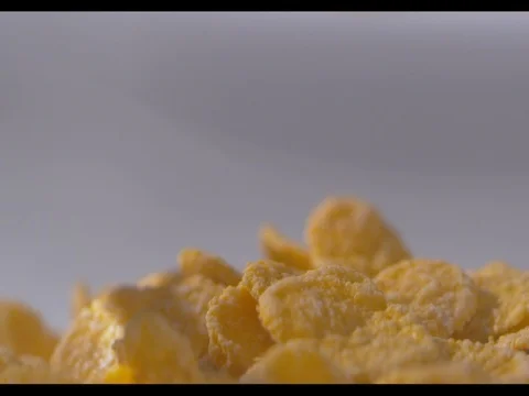 Corn flakes falling in a glass bowl, filling it up, white background Stock Footage 74184691
