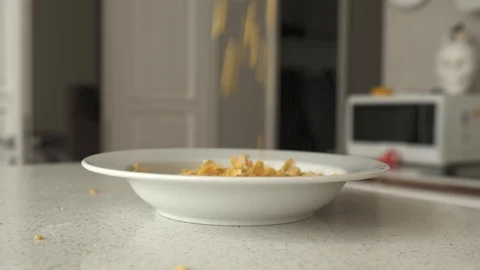 Corn flakes falling into a plate, 4K Stock Footage 124608389
