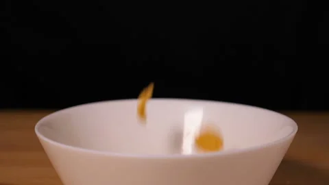 Corn flakes falling into a plate Stock Footage 126708047