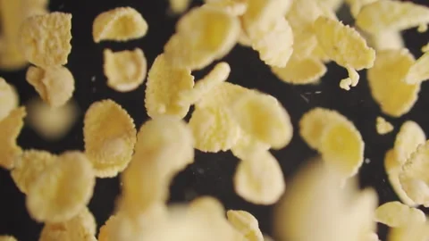Corn flakes flying in slow motion on a black background Stock Footage 255727324