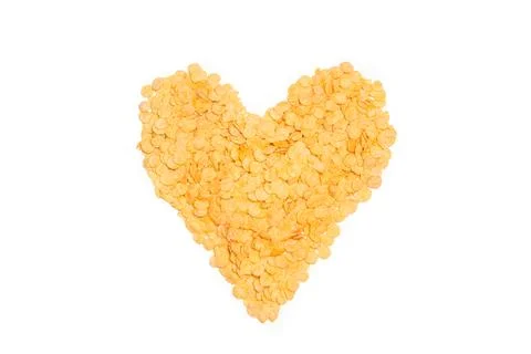 Corn flakes in heart shape on a white background with copy space Foto stock