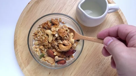 Corn flakes , nuts with milk on wood plate. Healthy breakfast. 4k video Stock Footage 249453176