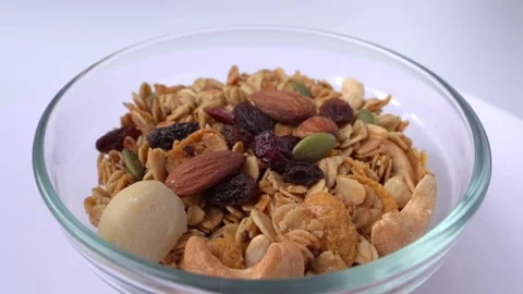 Corn flakes with nuts on white background. Rotating cereal. Stock Footage 249453185
