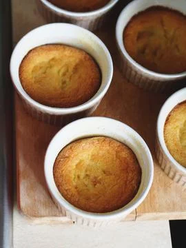 Corn flour sweet muffins in baking ramekins on wooden board Stock Photos