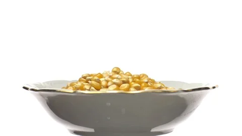 Corn grains in a bowl. Sweet maize, cereal grains. Rotation. Isolated on white. Stock Footage 101477386