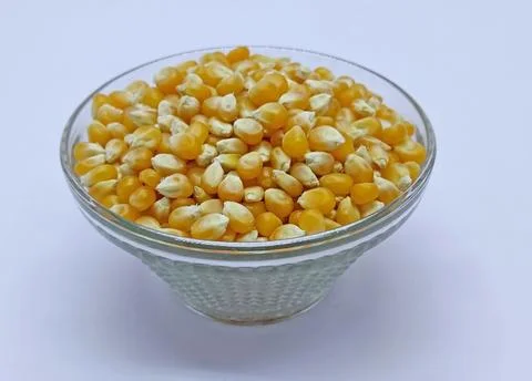 Corn kernels, Corns Seeds, Yellow dry corn grains in bowl on white background Stock Photos