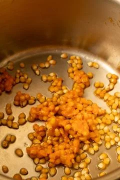From corn kernels to popcorn in the kitchen pot Stock Photos