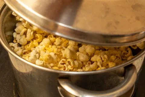 From corn kernels to popcorn in the kitchen pot Stock Photos