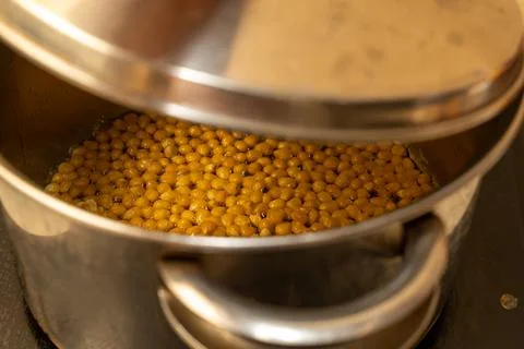 From corn kernels to popcorn in the kitchen pot Stock Photos
