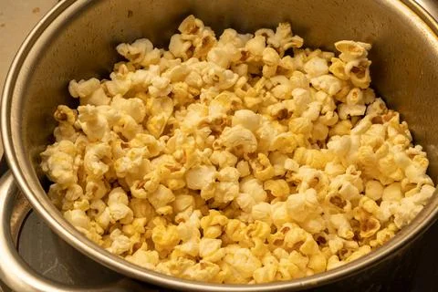 From corn kernels to popcorn in the kitchen pot Stock Photos