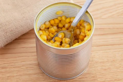 Corn in an open can with spoon Stock Photos