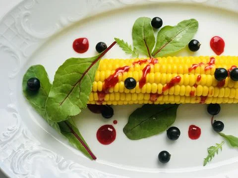 Corn on a platter with salad.  Stock Photos