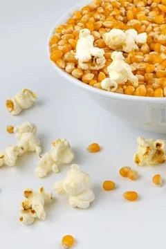 Corn for popcorn. Plate with corn kernels on white background. Stock Photos