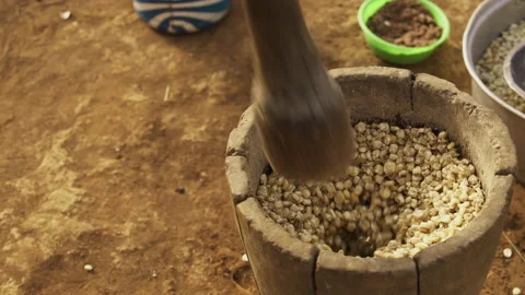 Corn is pounded with a pestle in a mortar Stock Footage 257683848