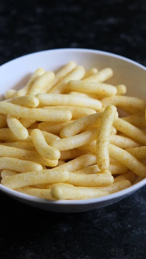 Corn Puff Snacks in a White Bowl on Dark Background Vidéo 331986969