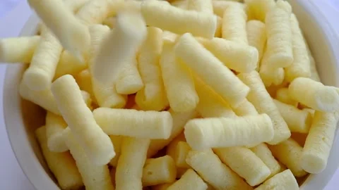 Corn puffs falling into a bowl Video stock 150339512