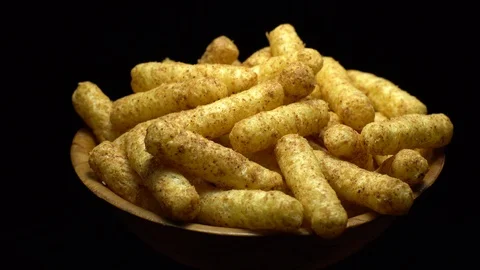 Corn puffs. Rotation. Close up.  Puffcorn with peanut flavor. Black background. Stock Footage 101299280