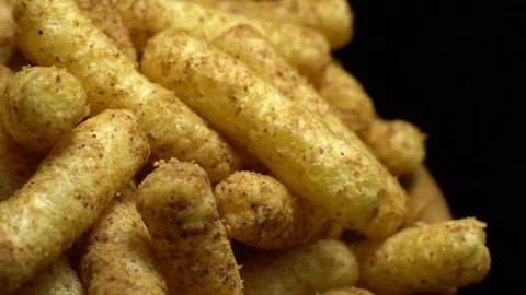 Corn puffs. Rotation. Close up.  Puffcorn with peanut flavor. Black background. Stock Footage 101302387