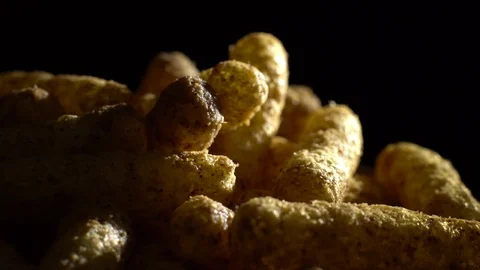 Corn puffs. Rotation. Close up.  Puffcorn with peanut flavor. Black background. Stock Footage 101302800