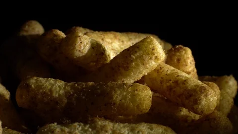 Corn puffs. Rotation. Close up.  Puffcorn with peanut flavor. Black background. Stock Footage 101302918