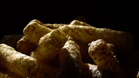 Corn puffs. Rotation. Close up.  Puffcorn with peanut flavor. Black background. Stock Footage 101302960