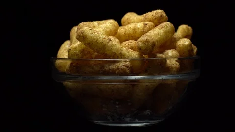 Corn puffs. Rotation. Close up.  Puffcorn with peanut flavor. Black background. Stock Footage 101303771