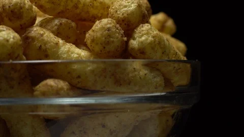 Corn puffs. Rotation. Close up.  Puffcorn with peanut flavor. Black background. Stock Footage 101303898
