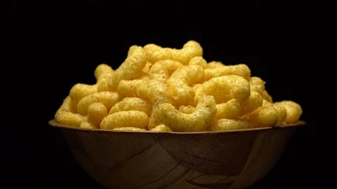 Corn puffs. Rotation. Close up.  Puffcorn with peanut flavor. Black background. Stock Footage 101313423
