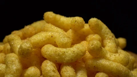 Corn puffs. Rotation. Close up.  Puffcorn with peanut flavor. Black background. Stock Footage 101313450