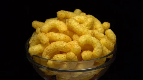 Corn puffs. Rotation. Close up.  Puffcorn with peanut flavor. Black background. Stock Footage 101314013