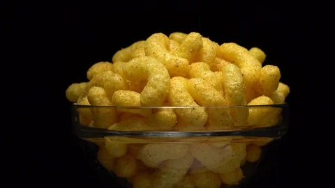 Corn puffs. Rotation. Close up.  Puffcorn with peanut flavor. Black background. Stock Footage 101314045