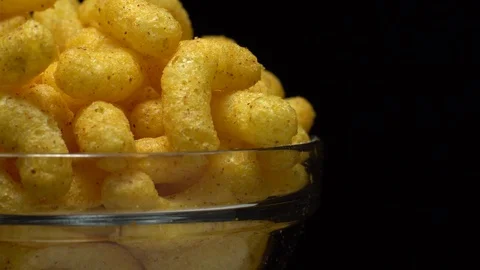 Corn puffs. Rotation. Close up.  Puffcorn with peanut flavor. Black background. Stock Footage 101314049