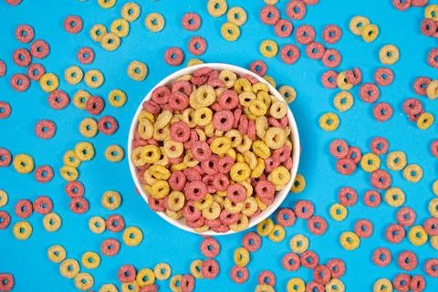 Corn rings of quick breakfast powder on a plate on a blue background, top view Stock Photos
