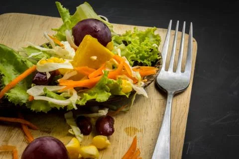Corn salad and red wine on black table spoon on the floor. Stock Photos