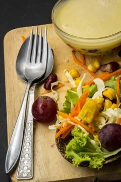 Corn salad and red wine on black table spoon on the floor. Stock Photos