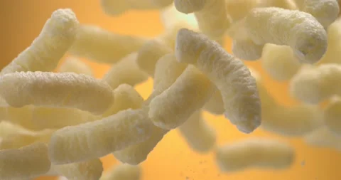 Corn sticks cheese puffs floating in the air slow motion Stock Footage 344848703