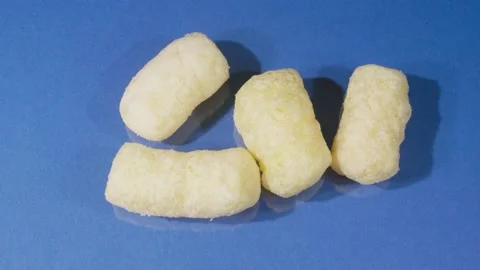 Corn sticks close up. Blue background. 4K video. Sweet food product. Видео 140634447