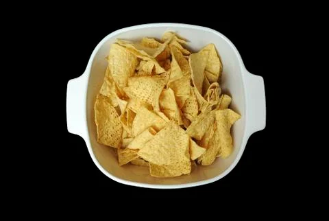 Corn tortilla chips contained in a white bowl isolated on black background. Stock Photos